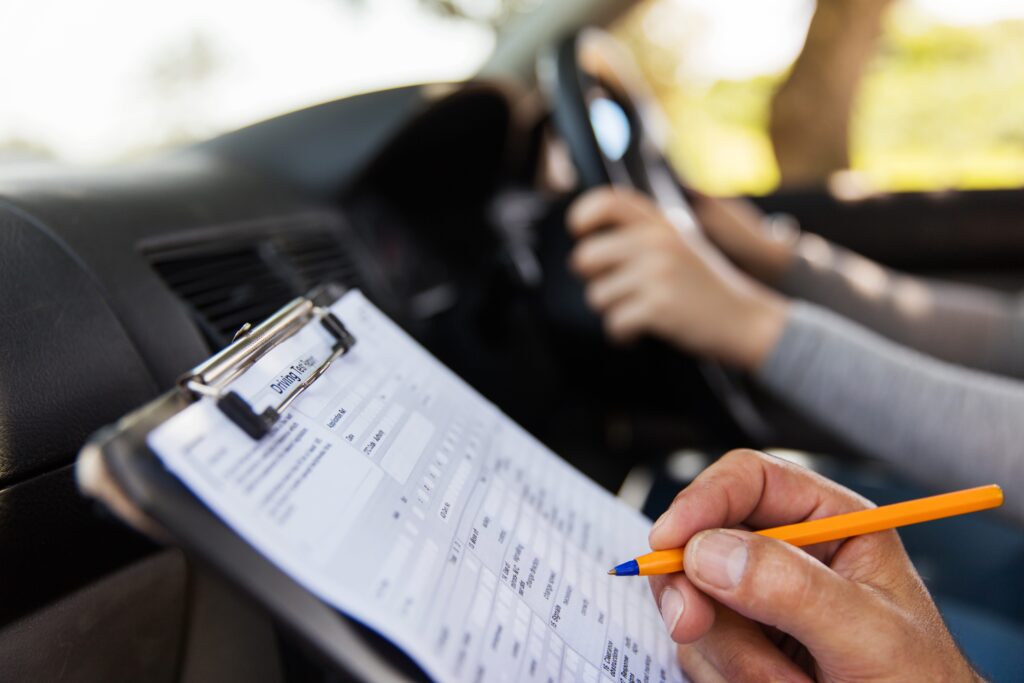 Close up image of a driving test examiner's clipboard in a car